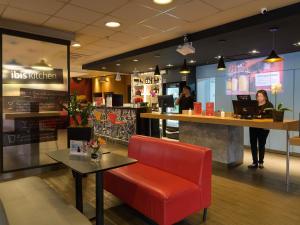 a restaurant with a red chair and a counter at ibis Aracaju in Aracaju