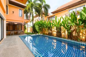 a swimming pool in front of a house at The Orange Villa Near Beach in Kamala Beach