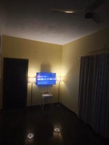 a room with a computer monitor on a table with lights at The Reset House Mangalore in Mangalore