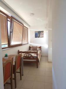 a dining room with a table and chairs and windows at Apartments Ravno in Plužine