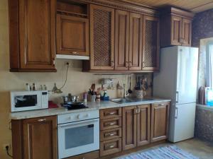 a kitchen with wooden cabinets and a white refrigerator at Пентхаус РіОНі Трускавець in Truskavets