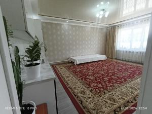 a room with a mattress on a red rug at Baktygul in Karakol