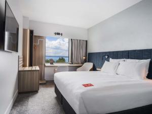 a hotel room with a large bed and a window at ibis Rotorua in Rotorua