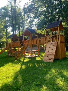 a wooden playground in a park with a slide at Готель in Yaremche