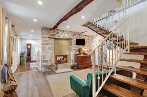 a living room with a staircase and a stone wall at Casa do Forno in Ponte da Barca