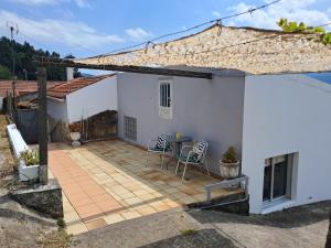 a white house with a patio with a table and chairs at lugar del pazo nª9-albeos in Albeos