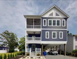 a blue and white house with a car parked in front at Sapphire Sol in Ocean City
