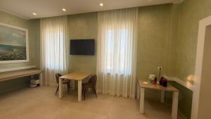a hotel room with a table and a television at Tenuta MAREALE in Anzio +35 photos