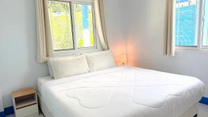 a white bed in a room with two windows at Temple Light in Ko Phangan +16 photos