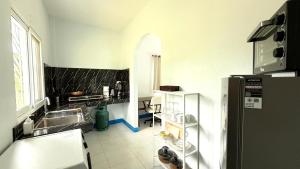 a kitchen with a sink and a refrigerator at Temple Light in Ko Phangan