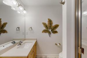 a bathroom with a sink and a mirror at Sapphire Sol in Ocean City +26 photos