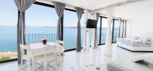 a white bedroom with a view of the ocean at VILA MOLET KOPER in Koper