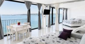 a bedroom with a table and a bed and a view of the ocean at VILA MOLET KOPER in Koper
