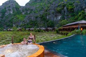 two people sitting in a hot tub at a resort at Karsia Retreat Ninh Binh in Ninh Binh