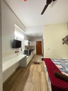 a living room with a bed and a kitchen at Zen Studio Paramount in Greater Noida