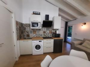 a kitchen with a washing machine and a microwave at SEL apartamentos rurales in Sel de la Carrera