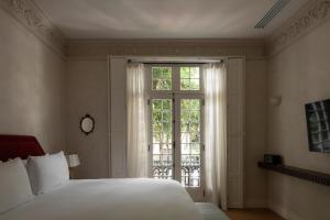 a bedroom with a bed and a window at El Cortés, Member of Relais & Châteaux in Mexico City