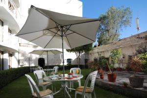 a table and chairs with an umbrella in a yard at San Agustin Posada del Monasterio in Arequipa