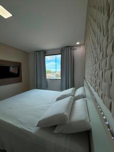 a bedroom with a bed with pillows and a window at Goiana Palace Hotel - Perto da JEEP, KLABIN, HEMOBRÁS, VIVIX in Goiana +43 photos