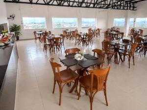a dining room with tables and chairs and windows at Hotel Vista Bela in Itamaraju +34 photos