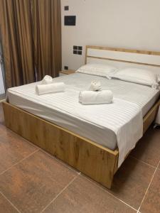 a large bed with two towels on top of it at HOTEL SARDA in Vau i Dejës
