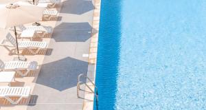an overhead view of a swimming pool with chairs and an umbrella at Centre Touristique Le Sable in Alger