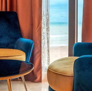 a room with chairs and tables and a view of the beach at Centre Touristique Le Sable in Alger