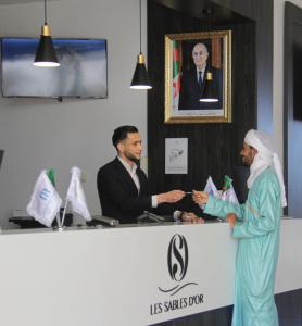 a man and a woman standing at a reception desk at Centre Touristique Le Sable in Alger +8 photos
