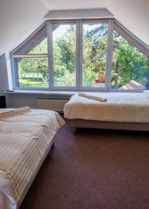 un dormitorio con dos camas y una ventana grande en Rezydencja PPPR, 