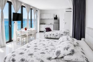 a bedroom with two beds and a kitchen with a table at VILA MOLET KOPER in Koper