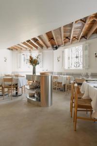 a dining room with white tables and chairs and a table at El Cortés, Member of Relais & Châteaux in Mexico City