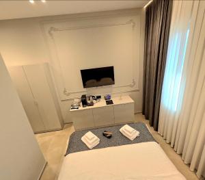 a bedroom with a bed and a tv on the wall at Motty Residence in Vicovu de Sus