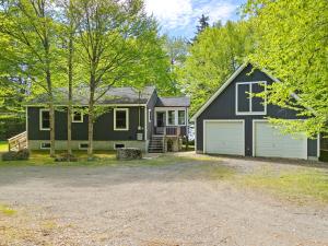 a house with a garage and a driveway at Waterfront cabin w/ outdoor firepit, dock, and lake views - dogs welcome in Greenville