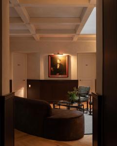 a living room with a couch and a painting on the wall at El Cortés, Member of Relais & Châteaux in Mexico City