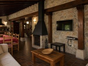 a living room with a stone wall with a fireplace at Las Hayucas in San Roque de Ríomiera
