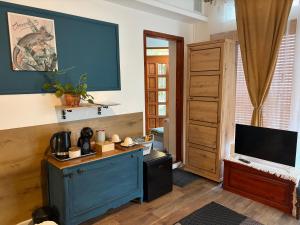 a living room with a blue cabinet and a television at Villa Lavanda Vendégház & Spa in Gyulakeszi