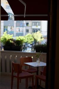 a table and chairs sitting on a balcony with a window at 2115 Boutique Hotel in Durrës +22 photos