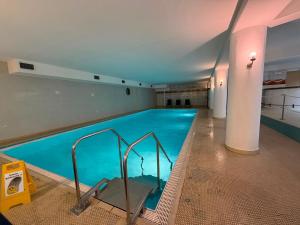 a large swimming pool with blue water in a building at See Sun in Uhldingen-Mühlhofen