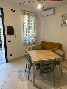 a dining room with a table and green chairs at Frontemare in Porto Garibaldi
