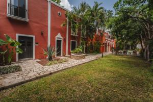 a yard in front of a red building at Casa Jade Hotel - Adults Only, Mérida in Mérida