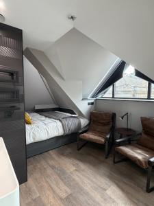 a bedroom with a bed and two chairs at Uno By The Sea - Boutique Hotel in St Ives