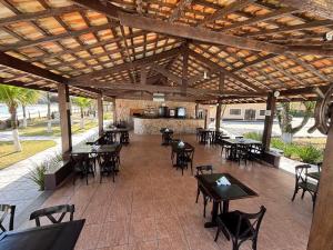 an outdoor patio with tables and chairs and a bar at Summit Beach Hotel Boiçucanga in Boicucanga