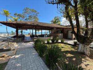 a house with a pavilion on the beach at Summit Beach Hotel Boiçucanga in Boicucanga