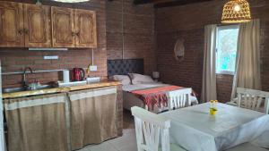 a kitchen with a table and a sink and a table and a kitchen with at Armonia cabaña de campo- Rincón de Afrodita in San Lorenzo