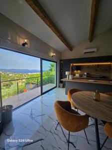 a kitchen with a table and a large glass window at La lézarde in Cavalaire-sur-Mer
