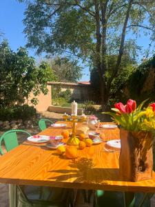 a wooden table with oranges and flowers on it at La Alcoba de los Cuentos in Urueña