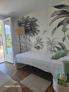 a bedroom with a bed with a mural of palm trees at La lézarde in Cavalaire-sur-Mer