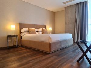 a bedroom with a bed with white sheets and pillows at Del Bono Central Hotel in San Juan +40 photos