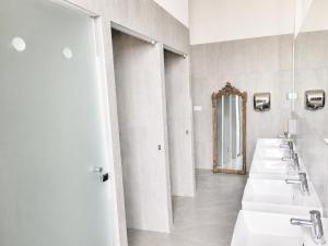 a bathroom with a row of sinks and a mirror at Château de Savonnières in La Bruère-sur-Loir +27 photos