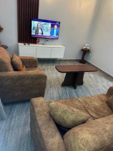 a living room with a couch and a tv at Fokam Hôtel in Nkongoa